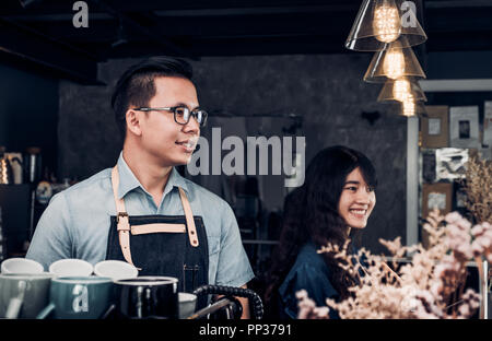 Männliche und weibliche Barista im Gespräch mit dem Kunden über schmeckt der Kaffee Tasse mit glücklichen Gefühl an der Theke bar Cafe. coffee shop Business Owner Konzept, Stockfoto