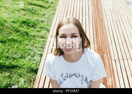 Nahaufnahme, Porträt einer jungen Frau auf der Bank in einem Stadtpark im Zentrum von Moskau posing Stockfoto