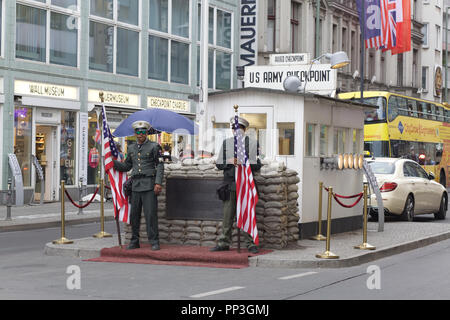 Akteure halten Fahnen am Checkpoint Charlie für den Tourismus in Berlin Deutschland Stockfoto