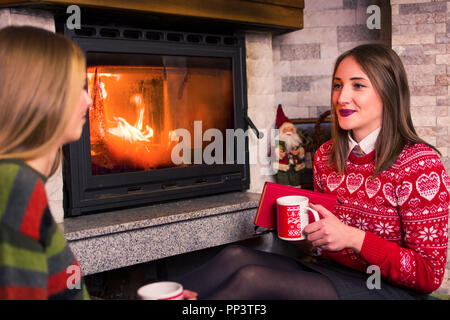 Mädchen durch den Kamin zu Hause chatten Stockfoto