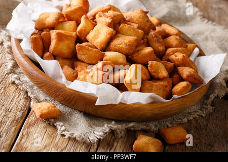 Golden Nigerianischen snack Chin Chin von deep-fried knuspriger Teig mit einem Muskatnuss close-up in einer Schüssel auf dem Tisch. Horizontale Stockfoto