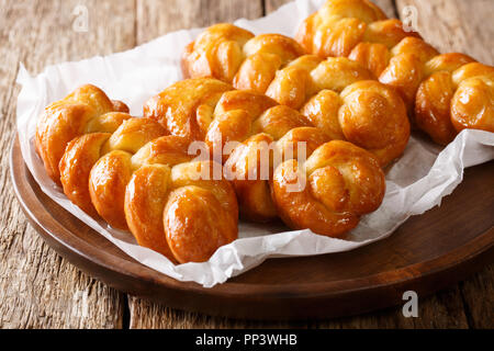 Frisch zubereitete Südafrikanischen Koeksisters frittiert, klebrige Donut in Zitrone Sirup getränkten schließen - bis auf einen Teller auf dem Tisch. Horizontale Stockfoto