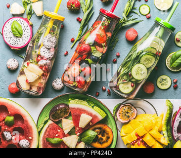 Vielzahl von gesunden detox infundiert Wasser mit bunten Früchten, Beeren aromatisiert mit frischen Kräutern, Gurke und Zitrone in Flaschen mit Strohhalm auf g Stockfoto