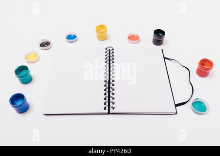 Set für Kreativität auf weißen Desktop: Eine offene Skizzenbuch neben Gläser Farbe für Zeichnung. Stockfoto