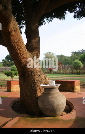 Einen Tontopf mit Trinkwasser liegt am Fuß eines Baumes in Adjumani, Uganda. Stockfoto