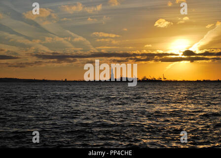 Sonnenuntergang über Jersey ny mit Freiheitsstatue am Horizont Stockfoto