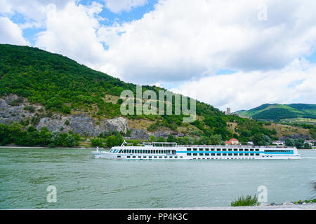 Großes Kreuzfahrtschiff auf der Donau und die Berge im Hintergrund. Stockfoto