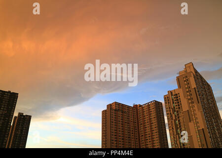 Regen Wolken bei Sonnenuntergang Nachleuchten Reflexionen Scrollen auf dem hohen Gebäuden Stockfoto