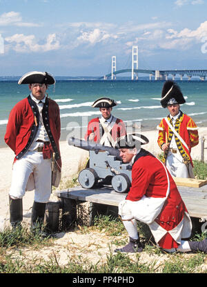 Britische Soldaten des Königs 8 Regiment zu Fuß Reenactment 1774-1781 Besetzung von Fort Michilimackinac, Michigan, mit Mackinac Bridge in backgrnd. Stockfoto