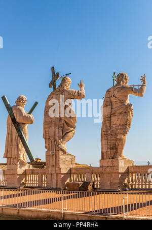 Statuen von Christus, Johannes der Täufer und ein Apostel auf der Oberseite der St. Peter Basilika Fassade. Stockfoto