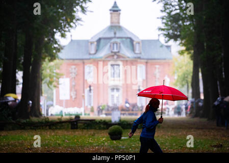 Soegel, Deutschland. 23. September 2018. Ein junges Mädchen mit einem roten Regenschirm in der Hand kreuzt die Spur, auf der die Jagd kurz vor dem Start des 60 Jagd ziehen auf Schloss Clemenswerth beginnt. Werden keine Tiere auf der Jagd getötet. Reiter und ein Pack von 30 Hunden folgen eine Spur der Duft, der vorher festgelegt wurde. Foto: mohssen Assanimoghaddam/dpa Quelle: dpa Picture alliance/Alamy leben Nachrichten Stockfoto