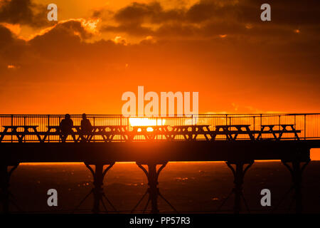 Aberystwyth Wales UK, 23. September 2018 UK Wetter: den feurigen Sonnenuntergang über dem Meer Pier auf der Equinox Sonntag Abend in Aberystwyth auf der West Wales Küste. Heute war der letzte Tag der astronomische Sommer - wenn die Tage und in der Nacht sind gleich lang. Ab morgen sind die Nächte länger als die Tage und markiert den Beginn der astronomische Winter auf der nördlichen Halbkugel Foto © Keith Morris/Alamy leben Nachrichten Stockfoto