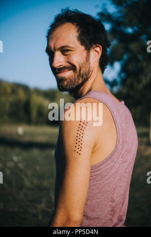 Porträt eines Mannes mit Kambo Zeremonie brennen Markierungen auf seinen Arm Stockfoto