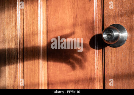 Schatten der Hand Einbrecher versucht, die Tür zu öffnen Stockfoto