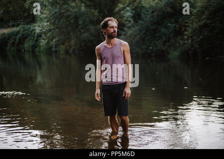 Portrait von bärtigen kaukasischen Mann stand in der Mitte von einem Fluss Stockfoto
