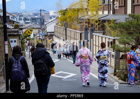KYOTO, Japan - 08 Feb 2018: Zwei bunte junge japanische Mädchen in traditionellen Kimonos gekleidet gehen hinunter eine Straße in Gion Stockfoto