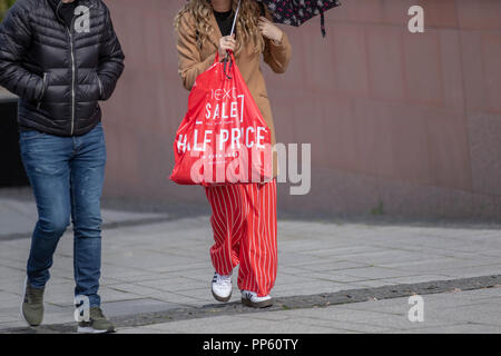 Käufer, die Ware an der nächsten halben Preis verkaufen, in Liverpool, Großbritannien erworben Stockfoto