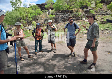 Gruppe der Touristen mit den Aboriginal Guide über bis zu Injalak Hill (Long Tom Träumen), Arnhem Land, Northern Territory, Top End, Australien zu Fuß Stockfoto