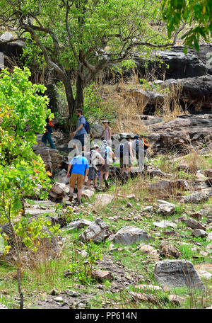 Lokaler Guide führt eine Tour bis Injalak Hill (Long Tom Träumen) mit seiner berühmten Felsen Kunstgalerien, Gunbalanya in Arnhem Land, Northern Territory, Australien Stockfoto