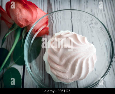 In einem Glas Vase köstliche Marshmallow, neben einer Rose. Die Aussicht von oben. Stockfoto