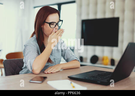 Müde Freiberufler Frau Gähnen am Laptop im Innenbereich Stockfoto