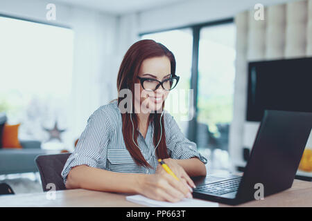Junge nerd Frau Notizen in Innenräumen, toothy Lächeln Stockfoto