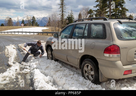 ADYGEA, Russland, 05. MAI 2015: Auto ist im Schnee in den Bergen hängen auf einer einsamen Straße Stockfoto