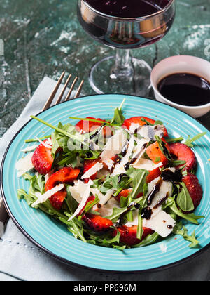 Salat mit Erdbeeren, Rucola und Parmesan beträufelt mit Balsamico glaze Stockfoto