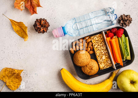 Gesunde Mahlzeit prep Container mit Cornflakes, Obst, Gemüse und Snacks. Essen zum Mitnehmen auf weißem Hintergrund, Ansicht von oben. Lunch Box zur Schule. Stockfoto