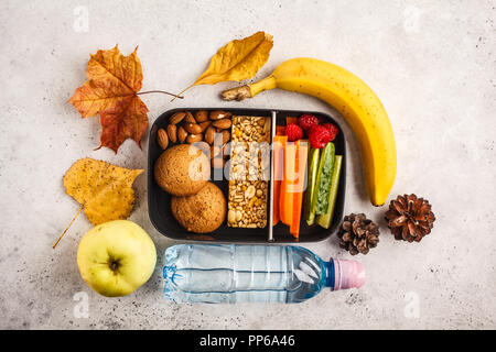 Gesunde Mahlzeit prep Container mit Cornflakes, Obst, Gemüse und Snacks. Essen zum Mitnehmen auf weißem Hintergrund, Ansicht von oben. Lunch Box zur Schule. Stockfoto