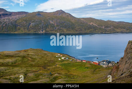 Ein Blick auf das winzige Dorf Djúpavík, Island, von den Klippen hoch über. Stockfoto