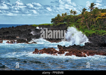 Wellen Absturz gegen die Lava Küstenlinie im Waianapanapa State Park auf Hawaii Insel Maui. Stockfoto