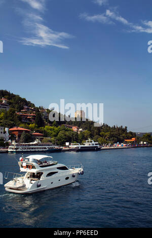 Nicht erkennbare Personen ride white Luxury Yacht am Bosporus in Istanbul. Große Motorboote und Rumelihisari oder Boğazkesen (mittelalterliche Festung) i Stockfoto