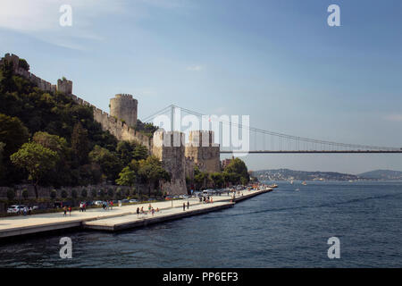 Anzeigen von Menschen zu Fuß durch Boshorus, FSM Brücke und Rumelihisari oder Boğazkesen (mittelalterliche Festung) in Istanbul. Es ist ein sonniger Sommertag. Stockfoto