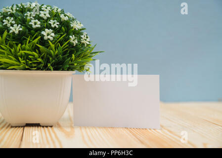Visitenkartenvorlagen und wenig Dekorativen Baum in weiße Vase auf hölzernen Tisch mit Platz für Text-ID hinzufügen. Und logo, business company Conc Stockfoto