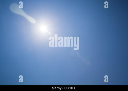 Lens flare Effekt über blauen Himmel und strahlenden Sonne Stockfoto