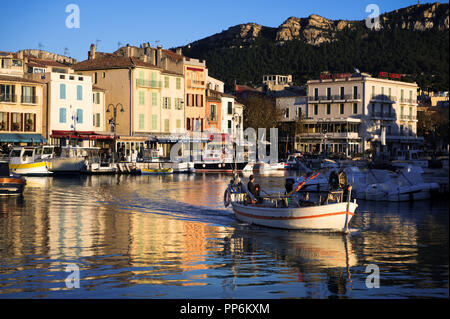 Fischer Boot verlassen ruhigen Hafen des antiken Cassis in Frankreich im Sonnenuntergang. Stockfoto