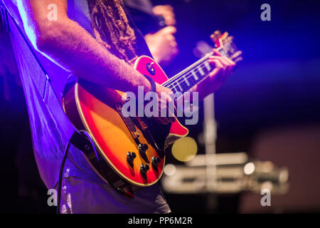 Gitarrist spielen auf E-Bass Gitarre auf der Bühne. Bunte, Weichzeichner und Unschärfe im Hintergrund. Stockfoto