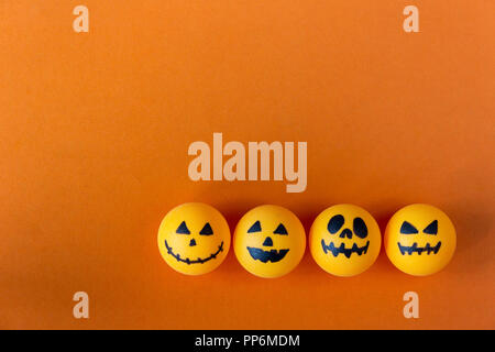 Halloween jack o lantern Eimer mit Süßigkeiten auf orange Hintergrund Stockfoto