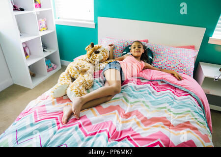 Tween girl entspannen Sie sich auf ihrem Bett, in Ihrem Schlafzimmer Stockfoto