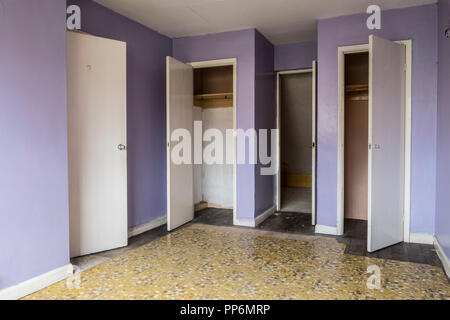 Innenansicht der leeren Schlafzimmer mit gelb und lila Wände in verlassenen Haus, weißer Kleiderschrank Türen. Stockfoto