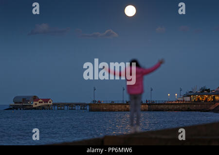 Zwei Tage vor der Ernte Mond, einem fast vollen Mond auf 98% steigt über Mumbles Pier in der Nähe von Swansea Stockfoto