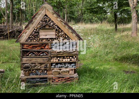 Große bug Haus mit mehreren Schichten unterschiedlicher Materialien in einem Garten. Stockfoto