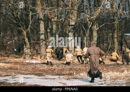 Re-Enactor gekleidet, wie Russische Sowjetische Infanterie Soldaten des 2. Weltkrieges WWII Schießen in Angriff im Herbst Wald. Stockfoto