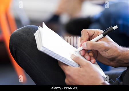 Hinweis auf ein Stück Blech mit einem Stift während einer Konferenz Stockfoto