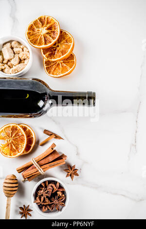 Zutaten für traditionelle Herbst trinken, Glühwein Cocktail - Rotwein, trocken Orangen, Rohrzucker, Honig, Zimt, Gewürze, Anis, auf weißem Marmor Stockfoto