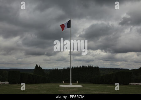 Französische nationale Flagge über den nationalen Friedhof von Douaumont (Nécropole nationale de Fleury-sur-Meuse) in Fleury-devant-Douaumont in der Nähe von Verdun in der Meuse region im Nordosten Frankreichs. Über 16.000 französische Soldaten in der Schlacht von Verdun im Ersten Weltkrieg gefallen sind auf dem Friedhof begraben. Stockfoto