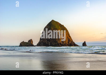 Schöne Haystack Rock, berühmte Wahrzeichen der Pazifischen Küste, bei Sonnenuntergang, Cannon Beach, Oregon, USA. Stockfoto