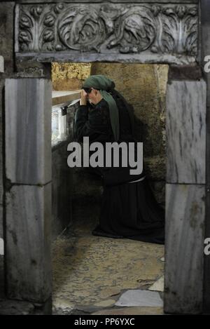 Israel. Jerusalem. Grab der Jungfrau Maria oder Kirche des Heiligen Grabes der Heiligen Maria. Christlichen Grab in den Kidron-Tal. Von östlichen Christen geglaubt, um die Grabstätte von Maria, die Mutter Jesu zu werden. Innenraum. Frau zu beten. Stockfoto