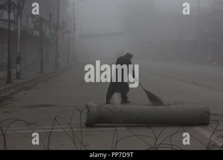 Srinagar, Indisch kontrollierten Teil Kaschmirs. 24 Sep, 2018. Eine Kehrmaschine reinigt eine Straße inmitten dichter Nebel in Srinagar Stadt, der Sommer Hauptstadt von Indien kontrollierten Teil Kaschmirs, Sept. 24, 2018. Credit: Javed Dar/Xinhua/Alamy leben Nachrichten Stockfoto